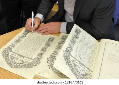 AUCKLAND  - OCT 31 2018:Rabbi signing Ketubah Jewish Prenuptial Agreement document in a traditional Jewish marriage that outlines the rights and responsibilities of the groom in relation to the bride.