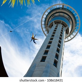 Auckland Sky Tower From Below With Blue Sky And Someone Jumping Off