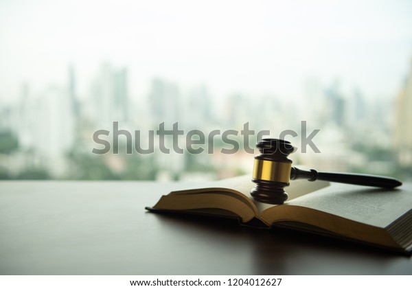 auction hammer or judge gavel with law books on\
legal desk with copy\
space.