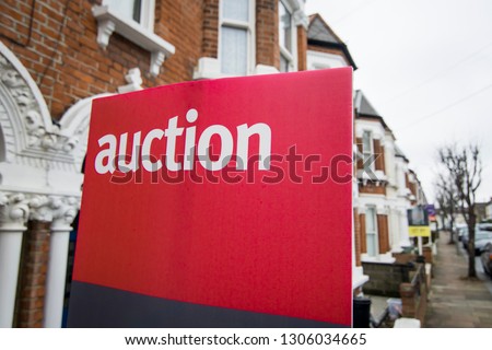 An auction sign on typical street of British terraced houses