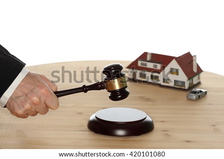 auctioneer with gavel in hand and house in background