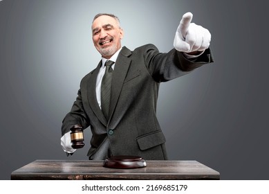 Auctioneer, salesperson with gavel at public auction. Senior male barker in formal elegant suit with auction hammer for close the bidding. - Shutterstock ID 2169685179