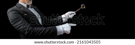 Auctioneer, salesperson with gavel at public auction. Crop view male barker in formal elegant suit with auction hammer for close the bidding.