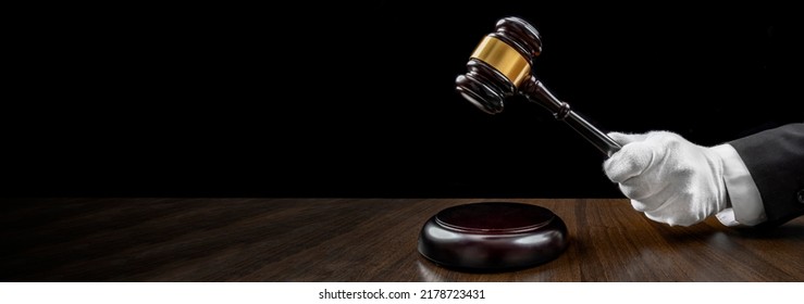 Auctioneer's hand, salesperson holding gavel at public auction. Close up view barker in formal elegant suit with auction hammer for close the bidding. - Shutterstock ID 2178723431