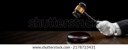 Auctioneer's hand, salesperson holding gavel at public auction. Close up view barker in formal elegant suit with auction hammer for close the bidding. Stockfoto © 