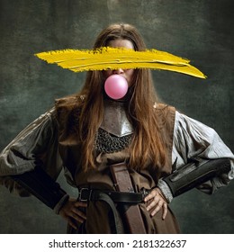 Audacity. Young woman as medieval warrior wearing historical outfit with yellow stroke of paint on her face. Contemporary artwork. Contemporary art, surrealism, avant-garde style. New vision, design - Shutterstock ID 2181322637