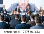 Audience attending a business conference with a panel discussion. Professional event with panelists and attendees engaging in discussions.