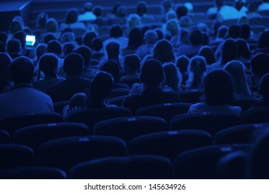 Audience In The Cinema. Silhouette Shot From Back In Blue Light.