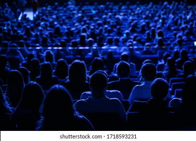 The audience in the cinema, the view from the back. Group of people at the business conference, back view, blue tones
