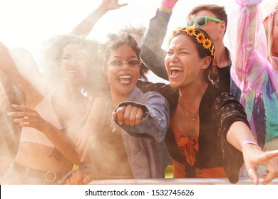 Audience With Colored Smoke Behind Barrier Dancing And Singing At Outdoor Festival Enjoying Music - Powered by Shutterstock