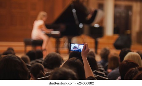 Audience In Concert Hall During Performing Piano Girl- People Shooting Performance On Smartphone, Music Opera