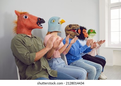 Audience In Different Funny Bizarre Silly Animal Masks Applauding At Interesting Lecture Or Workshop. Group Of Happy Foolish People With Horse, Bird, Dino, Ape And Frog Faces Clapping Hands At Seminar