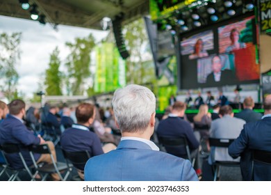 Audience Listening To Speaker On Screen During International Technology Conference