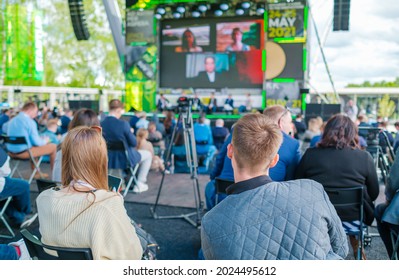 Audience Listening To Speaker On Screen During International Technology Conference