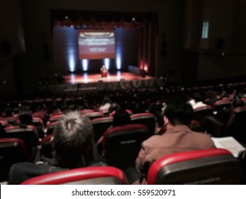 Audience Meeting Community In Seminar Hall With Ted Talk Live Show Blur Image Use For Background. Ted Talk Show With Many Crowd On Play Stage Of Theatre Concept.