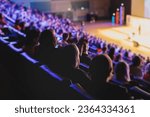 Audience at the modern conference hall listens to panel discussion, people on a congress together listen to speaker on stage at convention, business seminar, amphitheater venue for congress