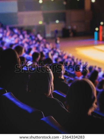 Audience at the modern conference hall listens to panel discussion, people on a congress together listen to speaker on stage at convention, business seminar, amphitheater venue for congress