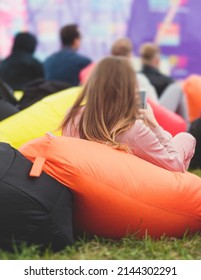 Audience At The Open Air Venue Listens To Lecturer, People On A Bean Bags Together Listen To Speaker On Stage At Master-class, Corporate Business Seminar Outdoors
