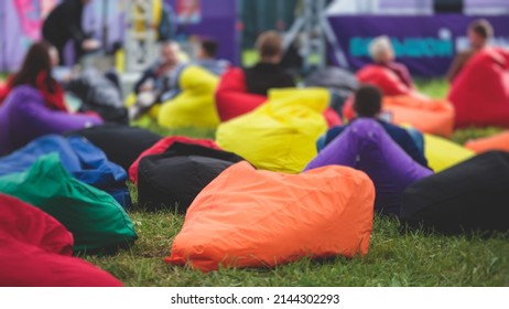 Audience At The Open Air Venue Listens To Lecturer, People On A Bean Bags Together Listen To Speaker On Stage At Master-class, Corporate Business Seminar Outdoors
