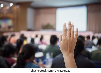 Audience Raising Hand While Speaker On Stage At Conference To Answer Question While Speaker Speech At Seminar Hall With Crowd Groups In Business And Education Concept