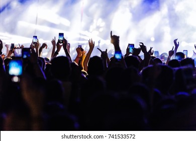 Audience recording video of band on mobile phone in concert.  - Powered by Shutterstock