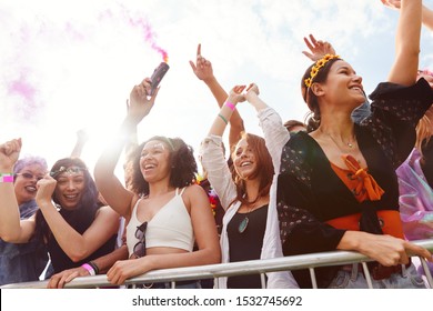 Audience With Smoke Flare Behind Barrier Dancing And Singing At Outdoor Festival Enjoying Music - Powered by Shutterstock