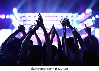 Audience watching a rock show with hands in the air - Powered by Shutterstock