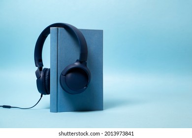 Audio Book Concept , Blue Book With Headphones Hanging On 