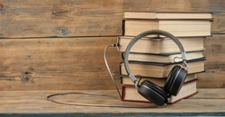 Audio Book Concept. Headphones And Book Over Wooden Table With Space For Your Text