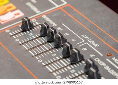 Audio control panel featuring Cyrillic labeled sliders, vibrato and wind settings, dark textured surface, white markings, orange accents, functional design for music production equipment, clean usab.