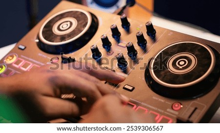 Audio engineer with headset mixing and mastering his recorded files, operating on a professional soundboard in home studio. Artist producer composing new tracks with sound effects. Camera A.