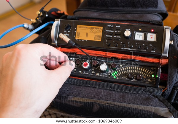 Audio engineer\
mixing live sound on a portable mobile recording sound pack, male\
hand in frame turning\
knobs