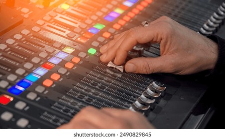 Audio engineer on audio mixer in studio adjusting volume levels. Broadcast, Music production, Sound engineer, Mixing console, Fader, Knob, Button. Isolated on black background - Powered by Shutterstock