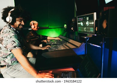 Audio engineers working on control desk panel for mixing new music album inside record studio - Focus on man face - Shutterstock ID 1963184122