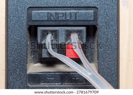 Audio input cables connected to a professional sound equipment panel with plus and minus markers