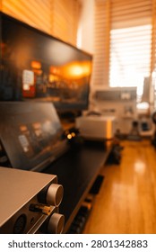 Audio interface and headphone amplifier with control knobs on a desk with monitors in a home recording studio