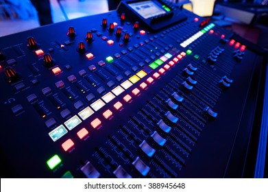 Audio mixer and microphone in blue colors. Close-up of the Mixing console. mixing knobs.