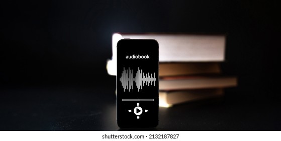 Audiobook Education. Smartphone Screen With Audiobook Application On Paper Books Black Background. Ebook E Learning Electronic Internet Mobility Concept