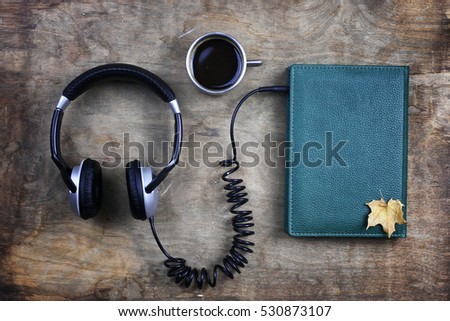 audiobook headphones and book on a wooden table