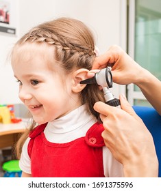 Audiologist Examining Little Girl Ear , Using Otoscope, In Doctors Office. Child Receiving A Ear Exam