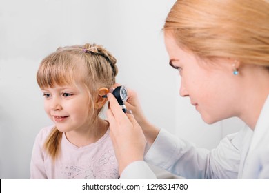 Audiologist Examining Little Patient With Otoscope, Hearing Exam Of Child