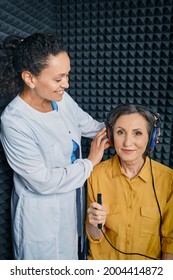 Audiometry. Audiologist Doing Hearing Exam To A Mature Woman In Soundproof Audiometric Cabin. Pure Tone Audiogram Test