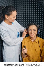 Audiometry Exam. Audiologist Doing Hearing Check-up To A Mature Woman In Soundproof Audiometric Cabin. Pure Tone Audiogram Test