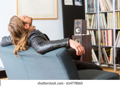 An Audiophile Leaning Back On A Couch Listening To Music