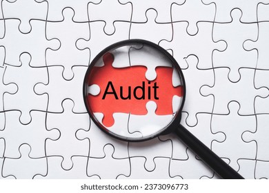 Audit wording with magnifier glass on red background among white jigsaw for quality control assurance and ISO concept. - Shutterstock ID 2373096773