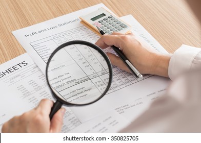 Auditor checking financial statement with magnifying glass. Audit Concept. top view.