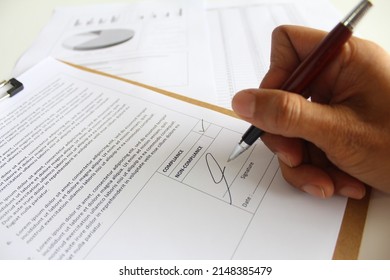 An auditor giving signature on a audit result either it is compliance or non compliance. Business improvement concept. Soft focus. - Shutterstock ID 2148385479