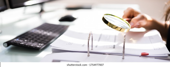 Auditor Investigating Corporate Fraud Using Magnifying Glass - Shutterstock ID 1754977007
