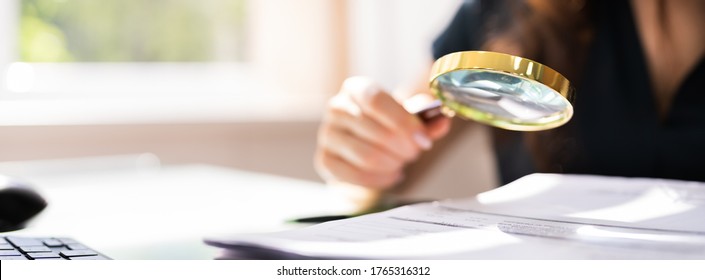 Auditor Investigating Corporate Fraud Using Magnifying Glass