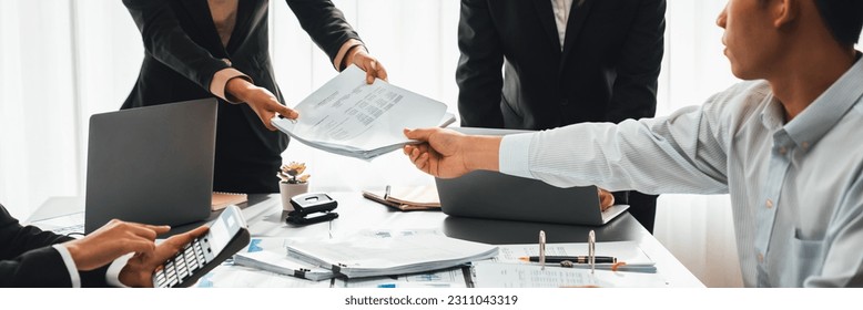 Auditor team collaborate in office, analyzing financial data and accounting record. Expertise in finance and taxation with accurate report and planning for company revenue, expense and budget. Insight - Shutterstock ID 2311043319